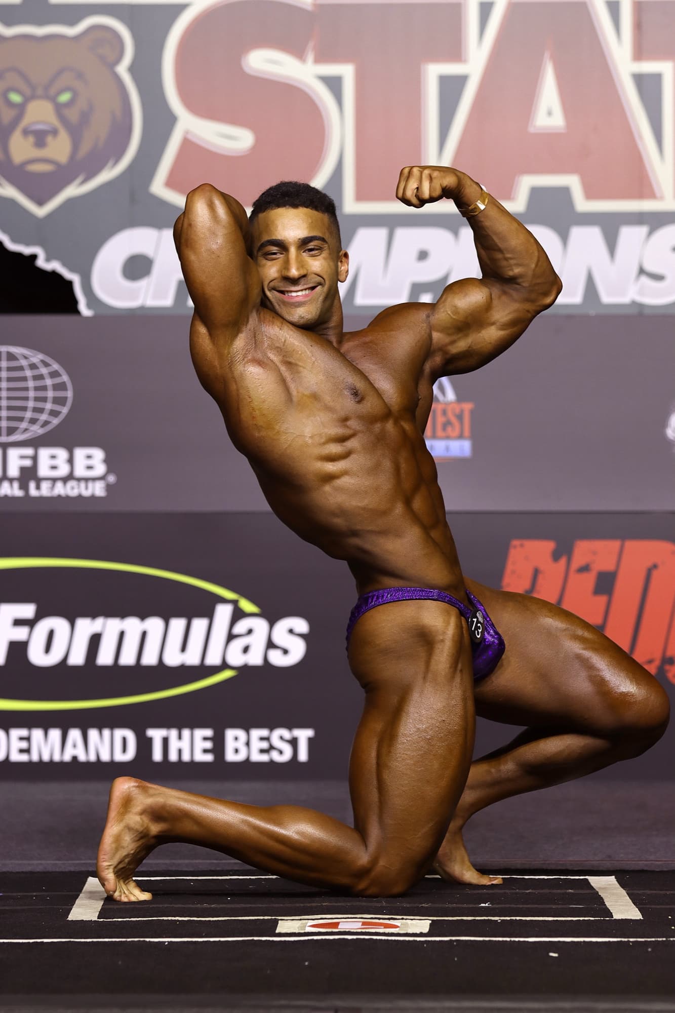 Omar Rantisi on stage, side abs and thigh pose